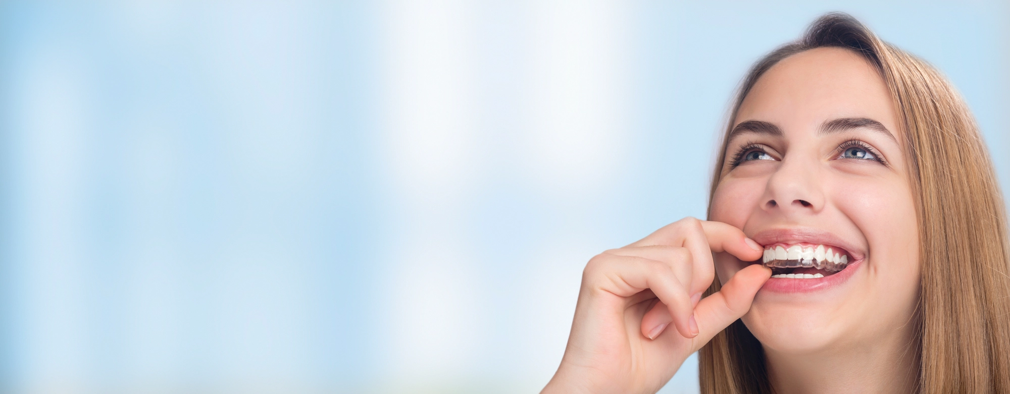 close up of woman with clear teeth aligners in McKinney TX