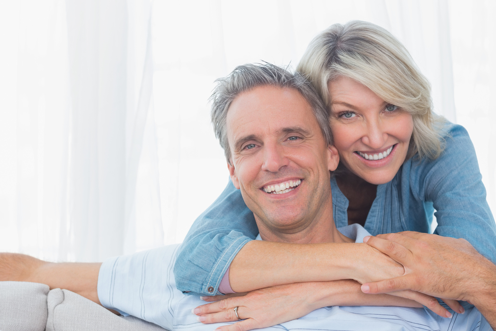 Couple smiling at the camera - restorative dentist McKinney TX | Dentures | Restorative Dentistry
