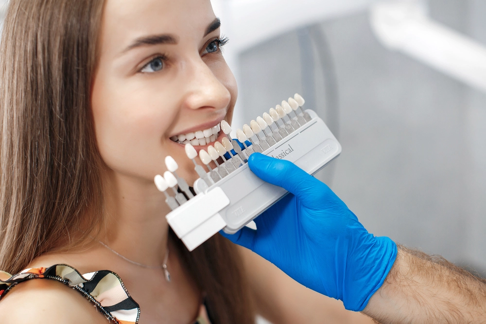 picture of woman smiling as dentist matches her tooth color dental veneers